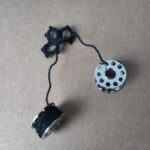 Angefangene Occhispitze. Die Fadenenden sind auf Nähmaschinenspulen gewickelt.