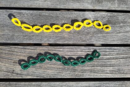 Ein gelber und ein grüner Reihenzähler. Sie besteht jeweils aus einer Kette von 10 Occhiringen.