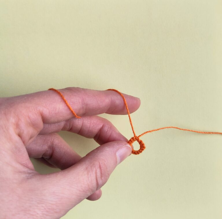 Handhaltung einer Occhiarbeit vor dem ersten Knoten eines Bogens, Foto