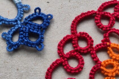 Ein blaues und ein rotes Stück Occhi-Spitze liegen sich gegenüber.