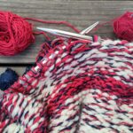 Ein angefangenes Strickprojekt mit dicken Nadeln, ("Hate Basket": Projekt zur Verwertung von blödem Garn für einen Einkaufkorb)