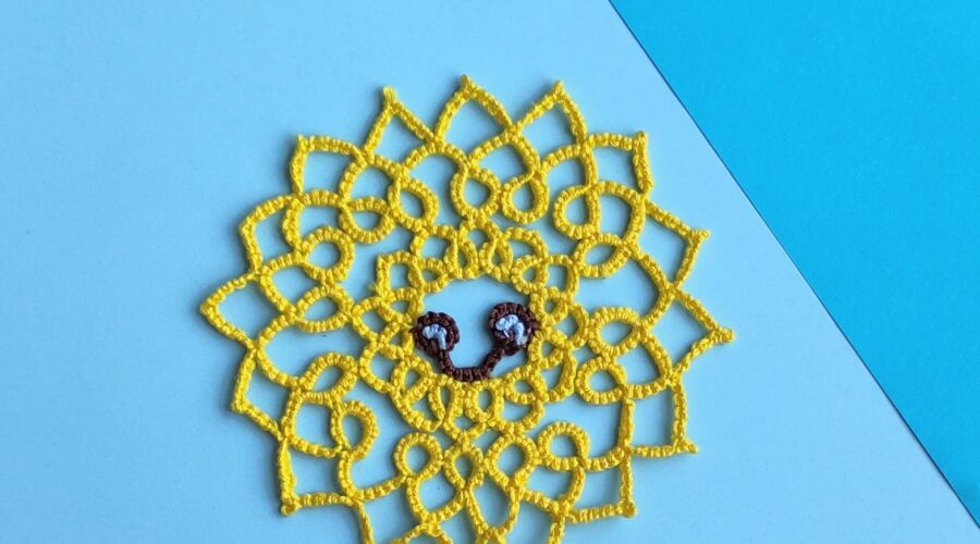 Eine lächelnde gelbe Sonne in Occhitechnik geknotet.