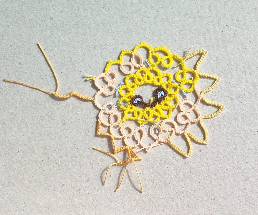 Teststück einer Sonne  in Occhitechnik mit verschiedenafrbigen Garnen und unterschiedlich gearbeiteten Sonnenstrahlen.