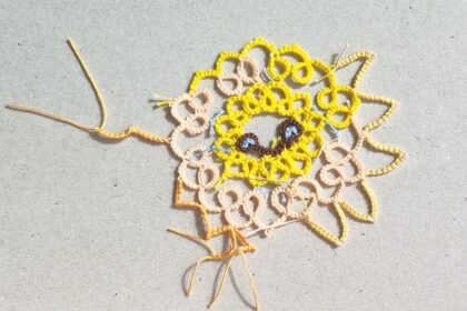 Teststück einer Sonne in Occhitechnik mit verschiedenafrbigen Garnen und unterschiedlich gearbeiteten Sonnenstrahlen.