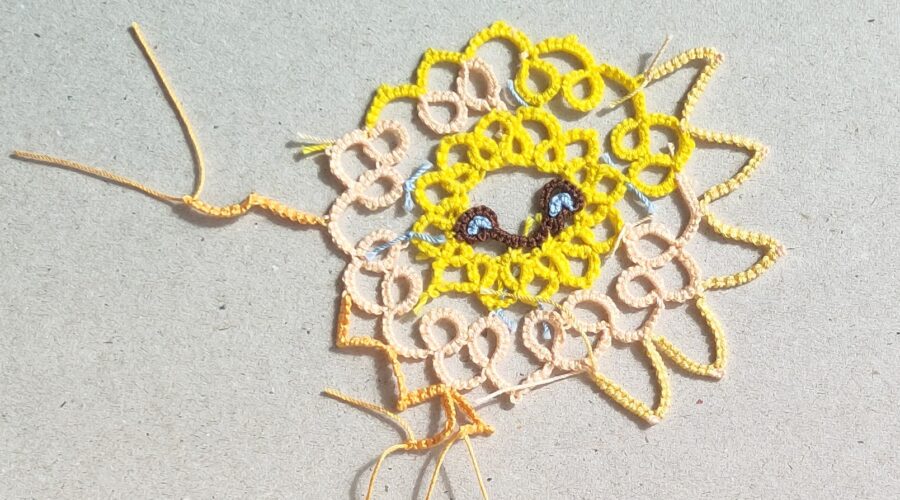 Teststück einer Sonne in Occhitechnik mit verschiedenafrbigen Garnen und unterschiedlich gearbeiteten Sonnenstrahlen.