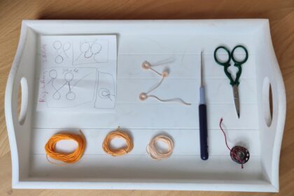 Ein weißes Tablett aus Holz mit verschiedenen Utensilien für Occhi ordentlich angeordnet